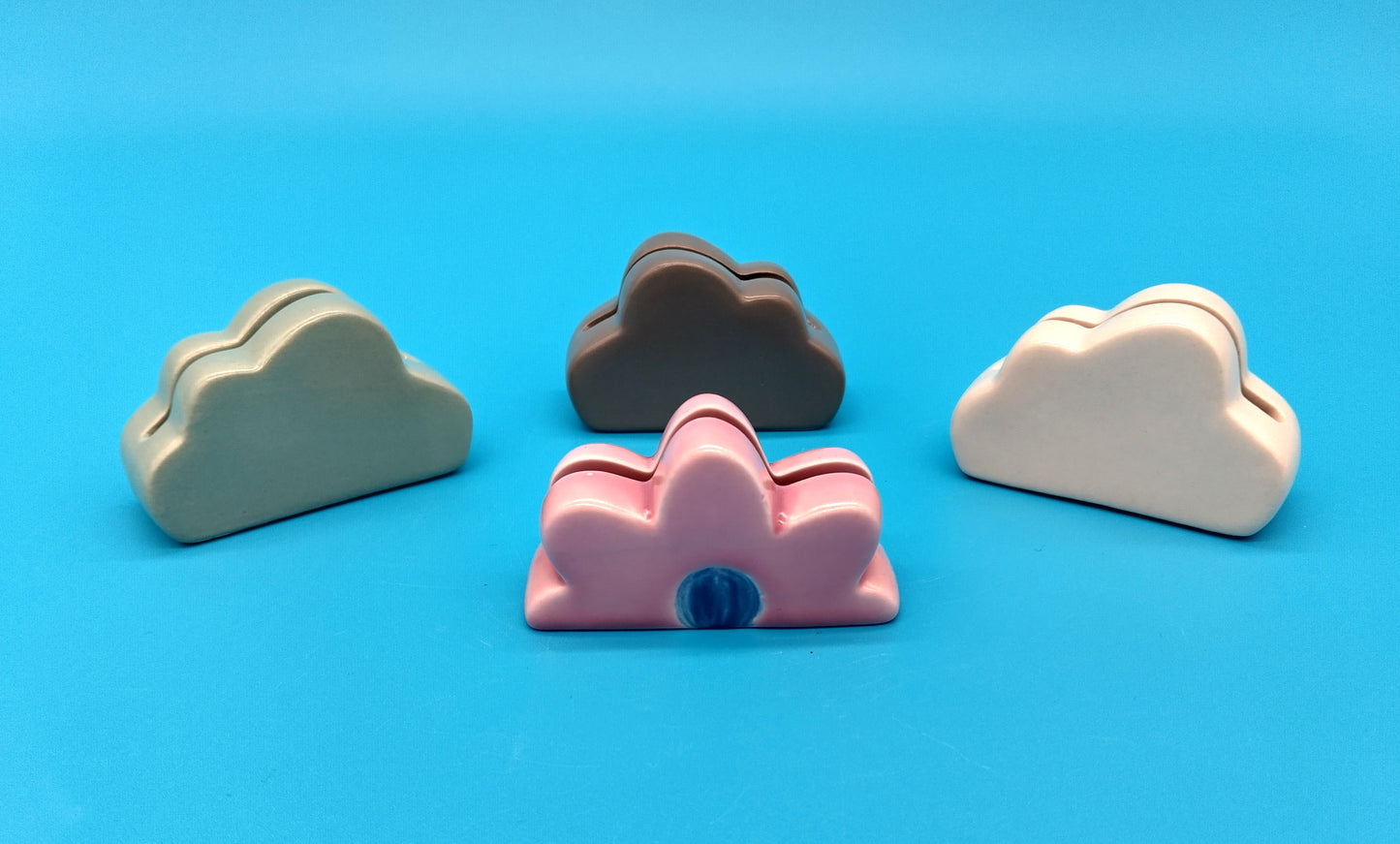 Ceramic Card Holder. 3 Clouds and 1 Flower. Enhance your workspace or home decor with the Ceramic Card Holder featuring three clouds and one flower.