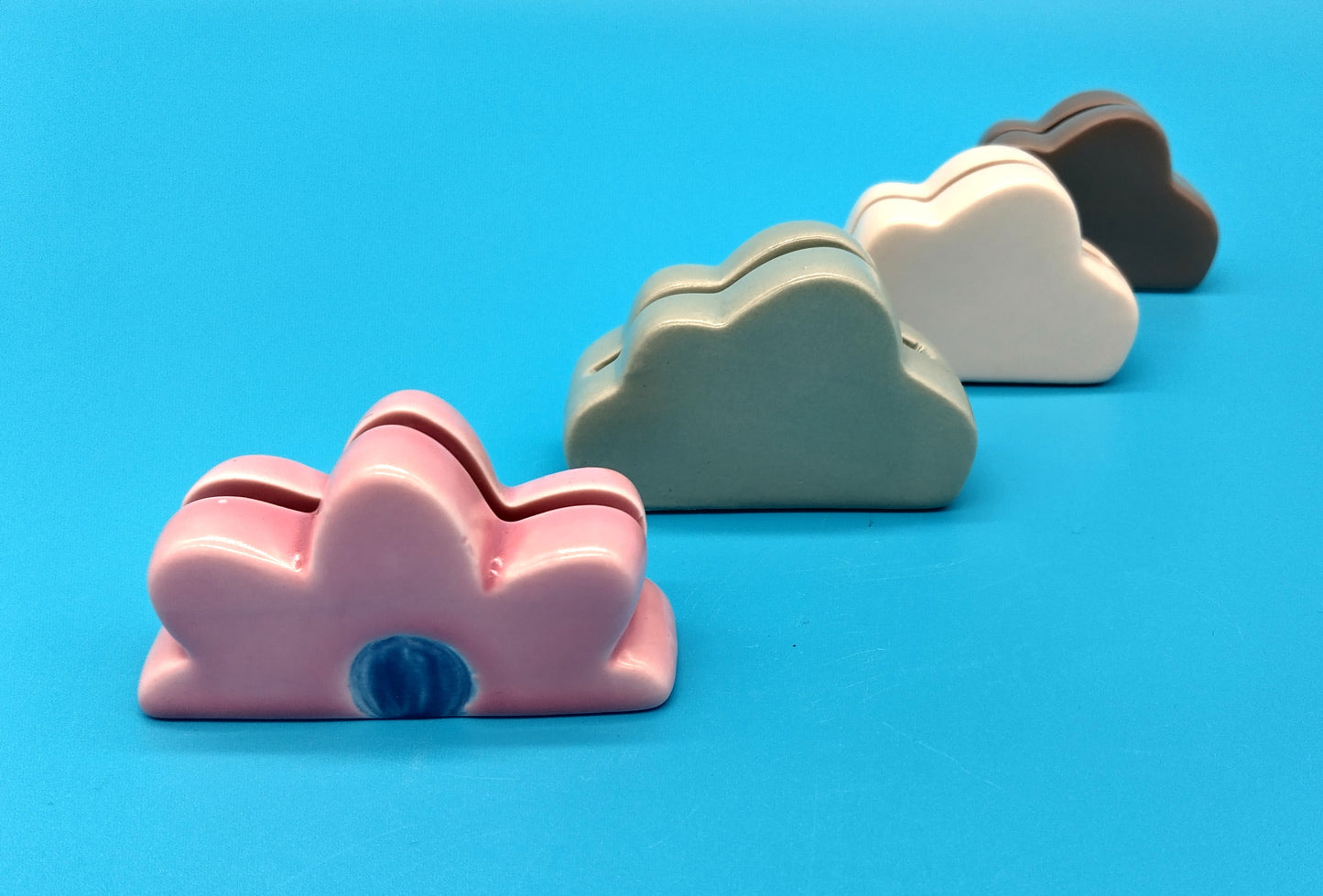 Ceramic Card Holder. 3 Clouds and 1 Flower. Enhance your workspace or home decor with the Ceramic Card Holder featuring three clouds and one flower.