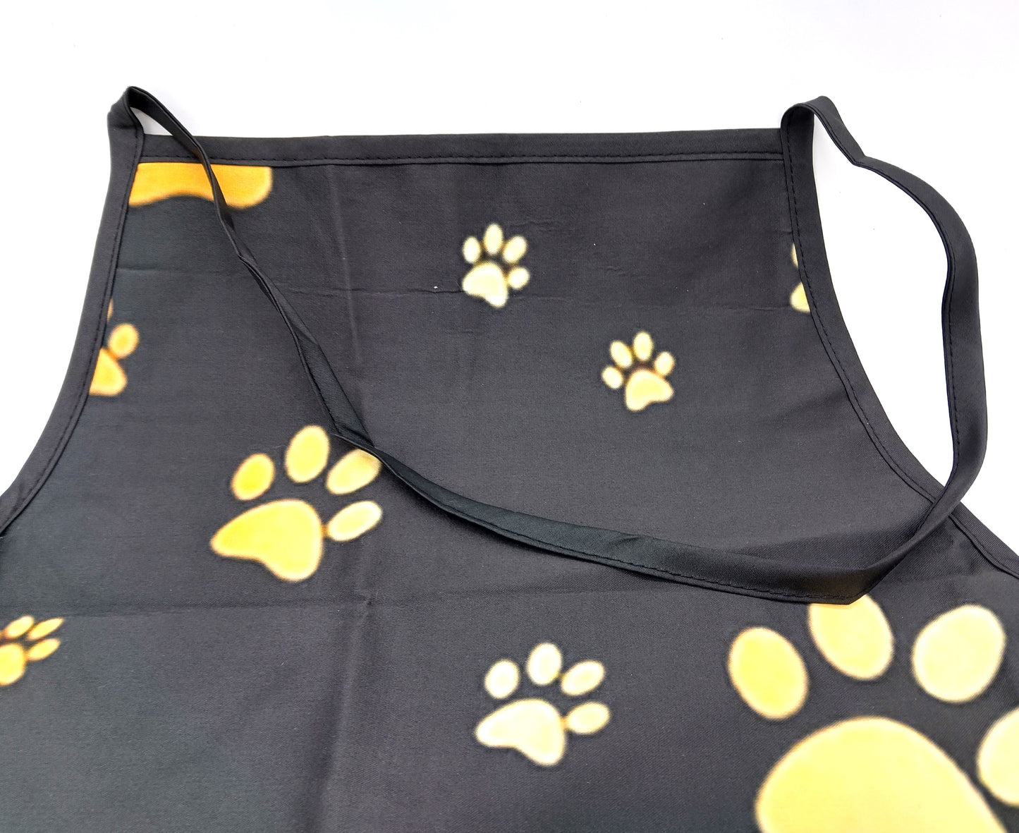 Kitchen Apron. Add a touch of style and functionality to your kitchen with the Gold Dog Paw Prints Kitchen Apron.