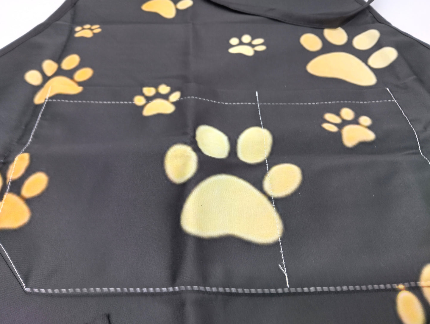 Kitchen Apron. Add a touch of style and functionality to your kitchen with the Gold Dog Paw Prints Kitchen Apron.